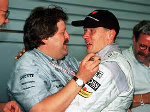 Lewis Hamilton im Gespräch mit Norbert Haug, beide lächeln und schütteln sich die Hände.