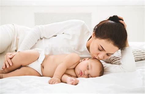 Nahaufnahme: Eine Mutter legt ihr schlafendes Baby sanft ins Bett