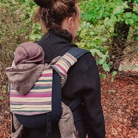 Illustration der M-Position beim Tragen eines Babys mit angehockten und leicht gespreizten Beinen.