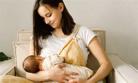 Eine Mutter, die ihr Baby richtig stillt, mit gut gestütztem Arm und geradem Rücken.