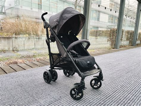 Baby-Paar sitzt in einem Joie Brisk Buggy auf einer belebten Straße