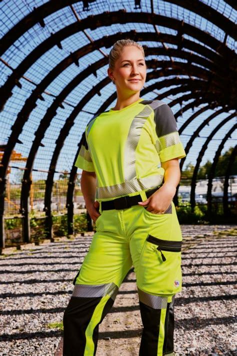 Frau, die sich Arbeitskleidung mit Stickerei ansieht