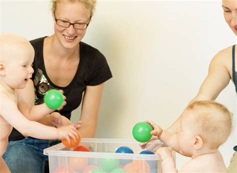 Foto von Eltern und Babys, die in einer PEKiP-Gruppe interagieren.