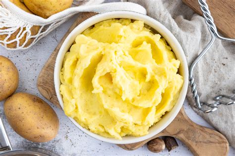 Schüssel mit frisch zubereitetem Kartoffelpüree für Babys, daneben ein Baby-Löffel