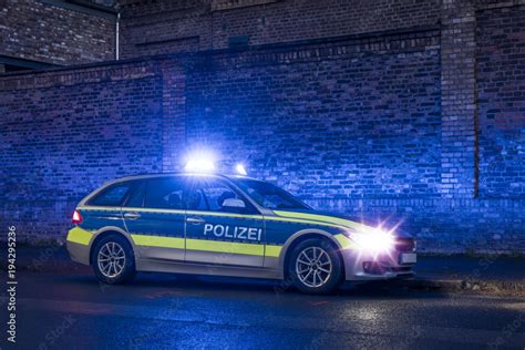 Polizeiauto mit Blaulicht vor einem Wohnhaus