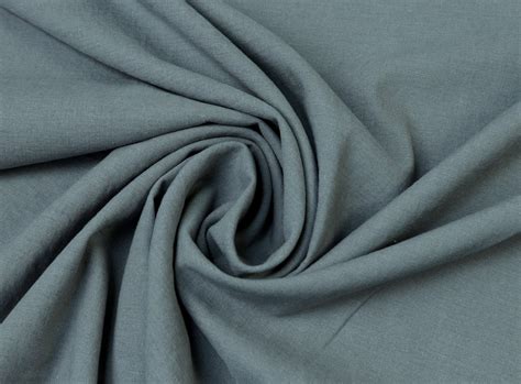 Detailaufnahme von Stoffmustern, die Atmungsaktivität und Pflegeleichtigkeit symbolisieren (z.B. Baumwolle, Leinen, Elasthan-Mischung)