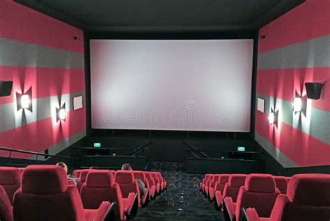 Innenansicht eines modernen Kinosaals mit bequemen Sesseln und großer Leinwand