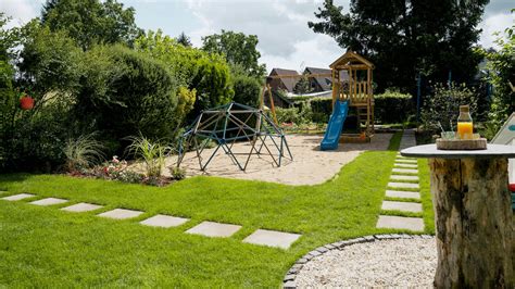 Außenansicht eines Forthauses mit Garten, Spielgeräten und Terrasse.