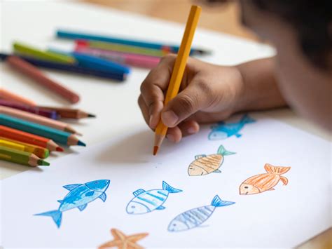 Ein Kind malt mit Wasserfarben auf Papier, während es im Hochstuhl sitzt