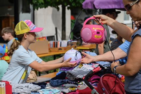 Foto von einem bunten Kinderflohmarkt mit vielen Ständen und spielenden Kindern