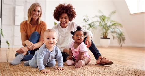 Foto von Eltern und Kleinkindern, die in einer Krabbelgruppe spielen und interagieren