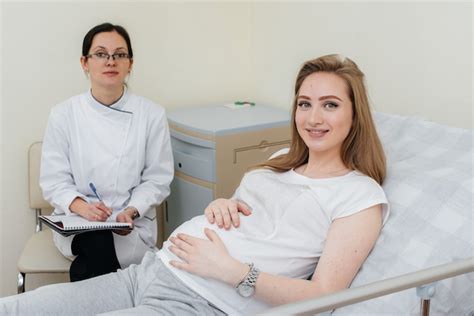 Eine Hebamme berät ein schwangeres Paar in einer freundlichen Praxis.