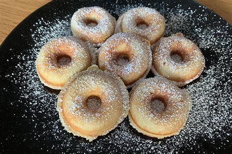 Bunte Mini-Donuts, frisch aus dem Donutmaker, mit Zuckerguss verziert.