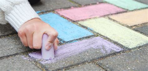 Eine bunte Auswahl an Straßenmalkreiden in verschiedenen Farben, die auf einem Gehweg liegen.