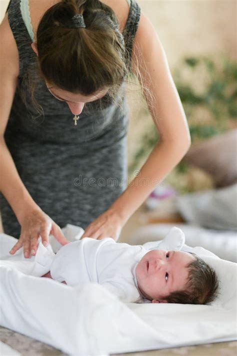 Frau wickelt Baby mit Mulltuch