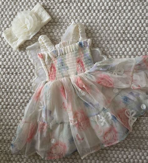 Beispiele für rosa Babykleider mit verschiedenen Designs: einfarbig, mit Rüschen, mit Tiermotiven.