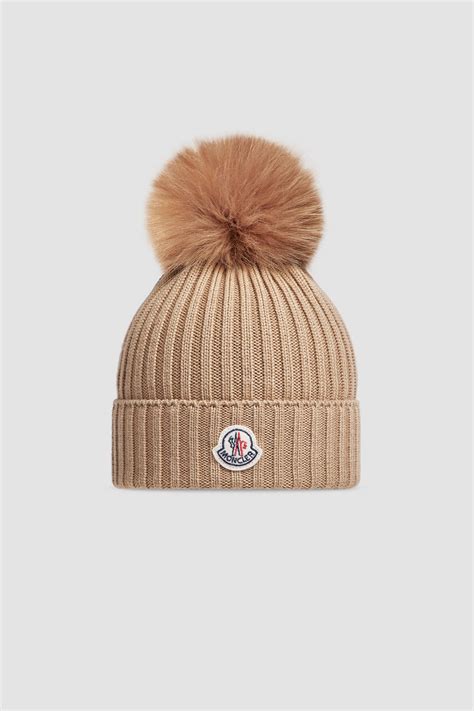 Design-Skizze einer Moncler Baby-Mütze mit stilisierten Ohrenklappen und Logo-Patch