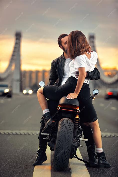 Eine junge Frau in einer stilvollen schwarzen Umstandsjeans und einem passenden Oberteil, die ihren wachsenden Bauch zeigt.