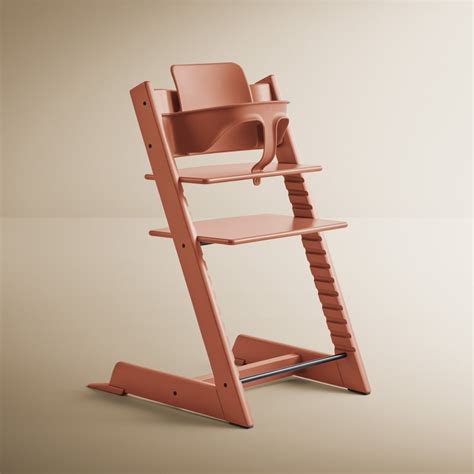 Ein Stokke Tripp Trapp Hochstuhl in natürlicher Holzoptik, der gute Gebrauchsspuren aufweist.