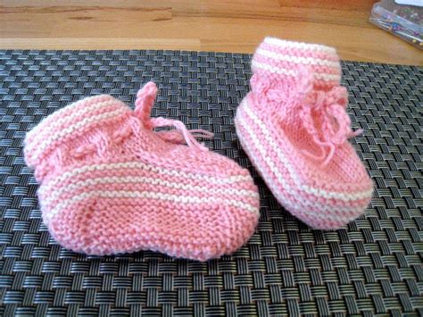 Gestrickte Babyschuhe, die ordentlich auf einem Regal aufbewahrt werden