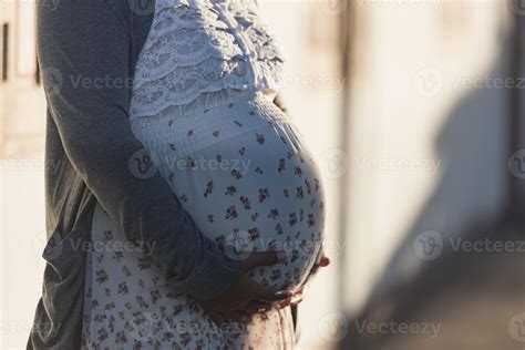 Eine schwangere Frau, die sanft ihren Bauch streichelt und mit ihrem Baby spricht