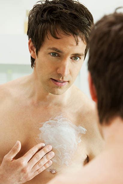 Frau, die sich eine feuchtigkeitsspendende Creme auf die Brust aufträgt