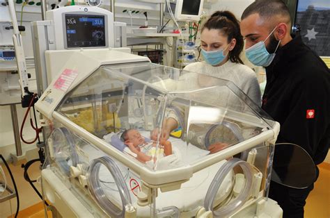 Krankenhausstation mit Inkubatoren und medizinischem Personal, das sich um Frühgeborene kümmert.