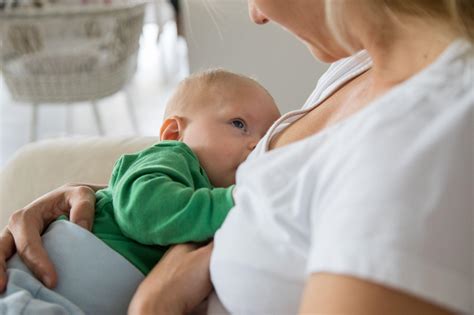 Eine Mutter stillt zwei Babys gleichzeitig in einer bequemen Position mit Hilfe eines Stillkissens.