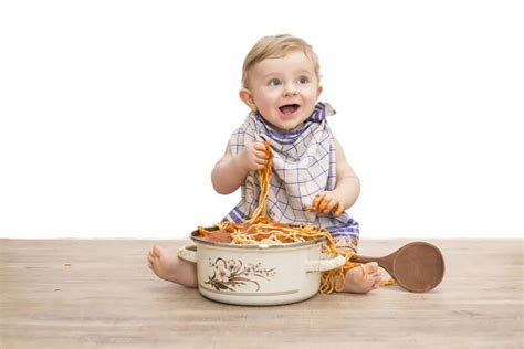 Illustration, die ein Baby beim Essen von Brei mit einem Löffel zeigt, anstatt aus einem Quetschbeutel zu saugen.