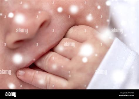 Nahaufnahme eines Babys, das seine Faust in den Mund steckt.