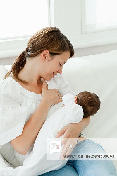 Eine Mutter, die ihr Neugeborenes stillt.