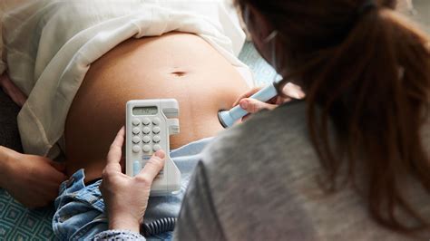 Hebamme hört mit dem Stethoskop die Herztöne eines Babys