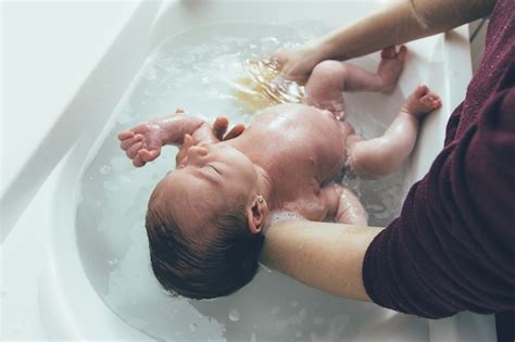 Illustration, die zeigt, wie man ein Baby sicher beim Baden hält