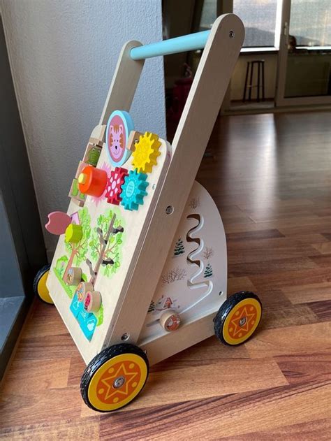 Bild einer stabilen Lauflernhilfe aus Holz mit Spielzeug