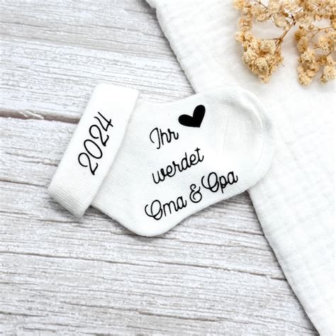 Geschenkbox mit Babysöckchen und einer Karte für werdende Großeltern