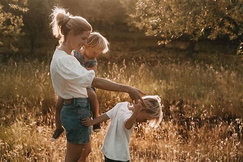 Eine Familie sitzt entspannt auf einer Wiese, die Eltern halten ihr Baby im Arm.