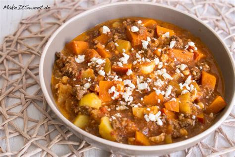 Ein Kochtopf mit köchelnder Bolognese-Sauce, daneben eine Schüssel mit gewürfelten Karotten