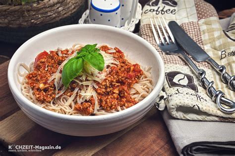 Ein Baby löffelt Spaghetti Bolognese aus einer Schüssel