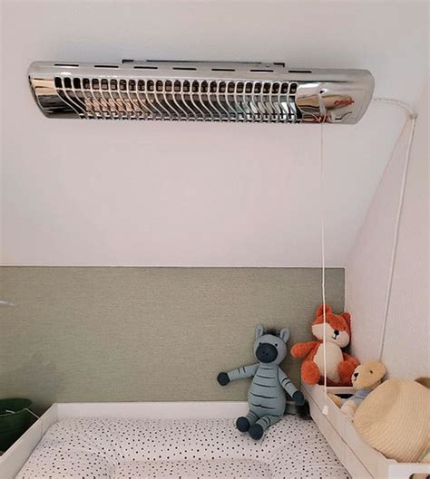 Baby-Heizstrahler zur Wandmontage über einem Wickeltisch.