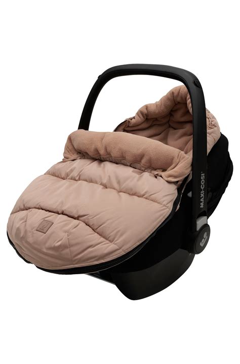 Baby in einem weichen Fusssack im Autositz, die Gurte sind gut sichtbar und eng anliegend.