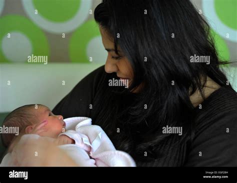 Foto einer Hebamme, die eine junge Familie betreut