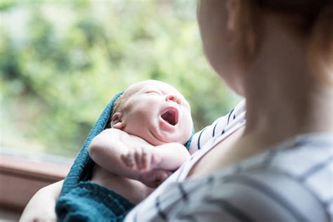 Fotografin mit Baby im Arm in einem hellen Klinik-Raum