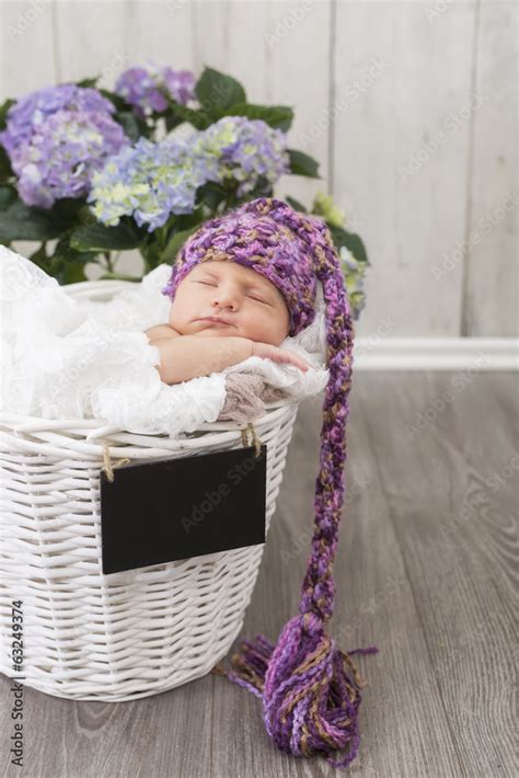 Neugeborenes Baby schlafend in einem Körbchen mit Blumen dekoriert