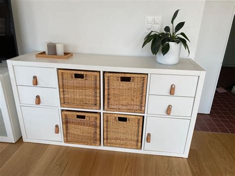 Detailansicht eines gut organisierten Wickeltisches mit Körben für Pflegeprodukte, griffbereiten Windeln und einer weichen Wickelauflage.