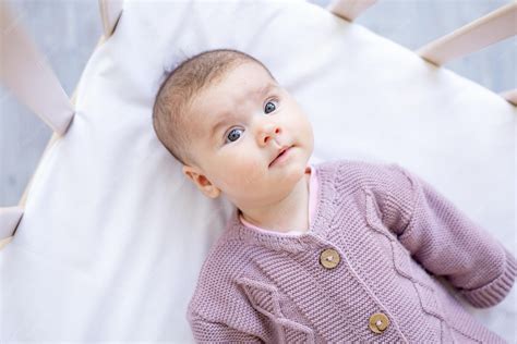 Baby in einem warmen Overall und Mütze, das ein Lächeln zeigt