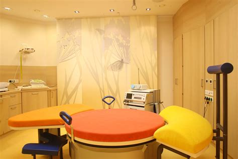 Schnittbild eines modernen Kreißsaals mit beruhigender Beleuchtung und Gebärinstrumenten.