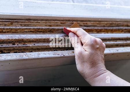 Nahaufnahme einer Hand, die einen Gipsabdruck mit Schleifpapier glättet