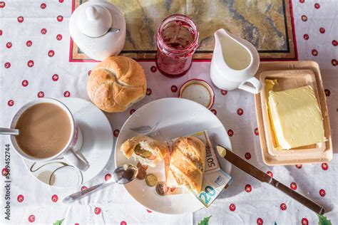 Frühstückstisch mit verschiedenen Broten und Brötchen, Kinder spielen im Hintergrund