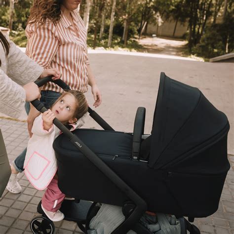 Ein Elternteil testet die Schiebekraft eines Kinderwagens im ZEKIWA Store.