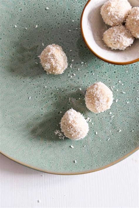 Kleine, runde Stillpralinen, bestreut mit Kokosraspeln, auf einem Teller